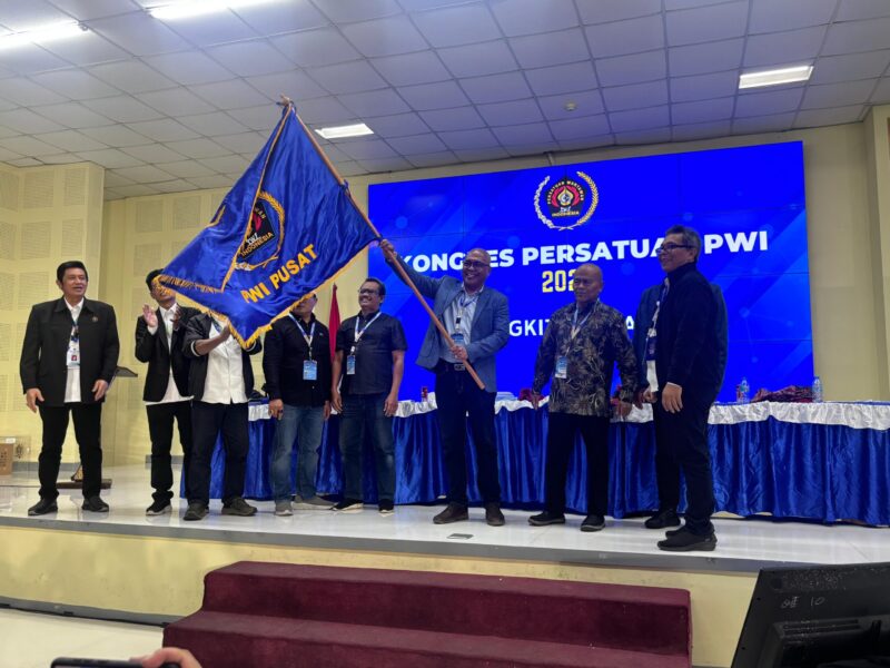 Akhmad Munir, Mengangkat bendera Pataka saat terpilih menjadi ketua PWI Pusat periode 2025-2030 (Foto: Ist)
